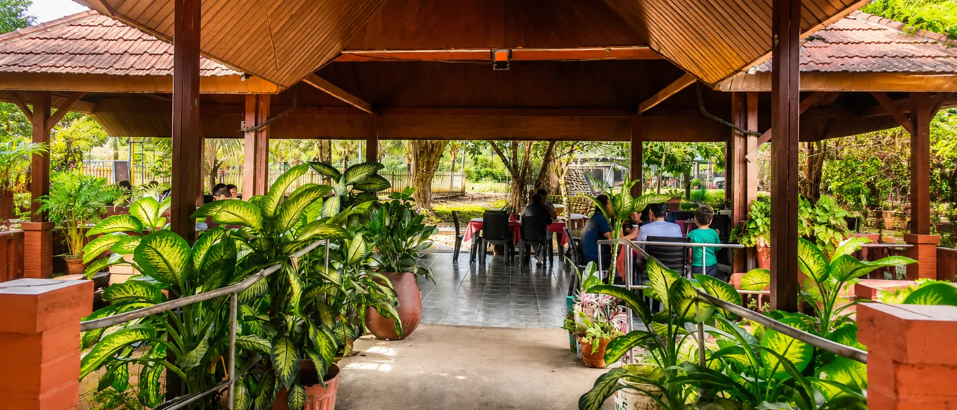 Comedor campestre bajo cabaña, entre plantas tropicales